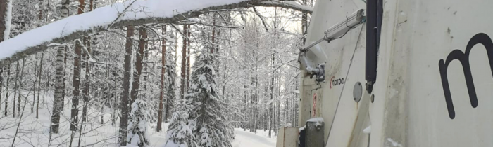 Tykkyluminen oksa jäteauton edessä tiellä.